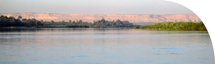 Downstream view of the eastern cliffs behind Amarna, as the river swings past them to the left.