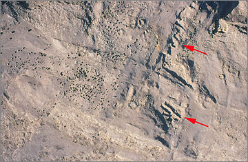 Aerial photograph of small surface quarries on the desert above Queen Tiy’s quarry. The red arrows mark the positions of two sets of shallow quarries