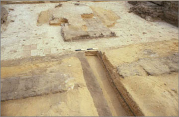 The gateway in the first pylon after re-excavation in 1987. The original gypsum-concrete layer has been exposed. It is this which provides the authority for restoring the pavement in new limestone blocks. Note the central raised part, which must have supported stonework at a higher level, probably a stone platform.
